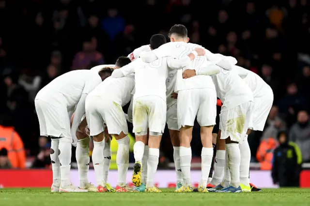 Players of Arsenal speak in a huddle ahead of the second half