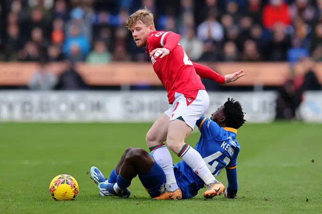 Max Mata of Shrewsbury Town and Andy Cannon of Wrexham battle for the ball