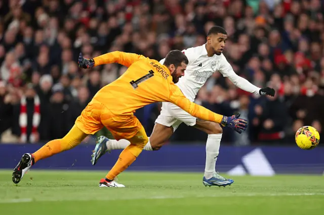 Reiss Nelson of Arsenal runs with the ball past Alisson Becker of Liverpool