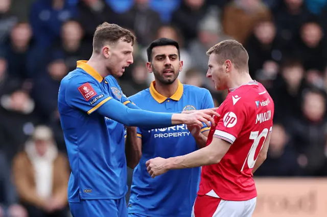 Joe Anderson of Shrewsbury Town clashes with Paul Mullin