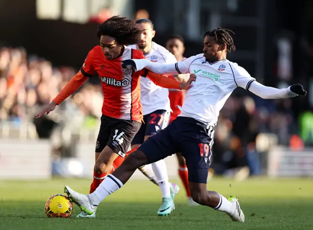 : Tahith Chong of Luton Town is challenged by Paris Maghoma