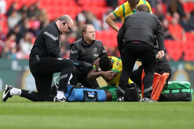 Daryl Dike of West Bromwich Albion covers his face as he is examined by physios