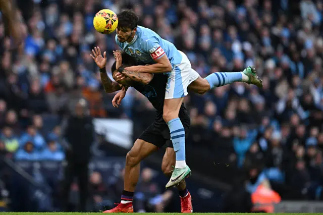 Ruben Dias wins a header from Huddersfield Town's Welsh midfielder Sorba Thomas