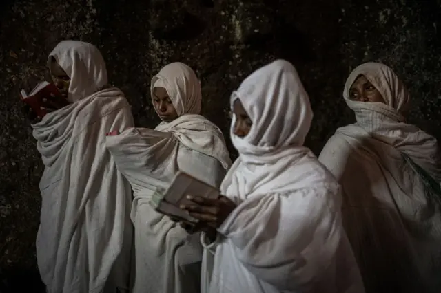 Pilgrims read prayers from bibles during the celebrations of Gena, the Ethiopian Orthodox Christmas, at Bete Mariam church in Lalibela on January 8, 2024.