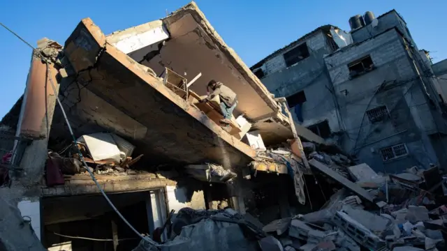 Palestinians from the Brais family search for missing people under the rubble following an Israeli air strike in Khan Yunis