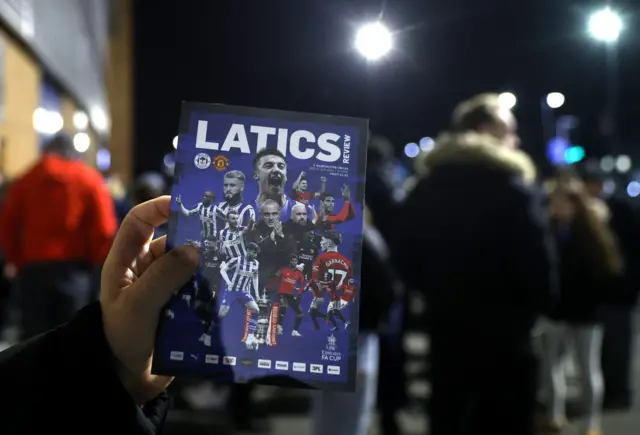 A fan holds up a programme ahead of Wigan v Man Utd in the Premier League