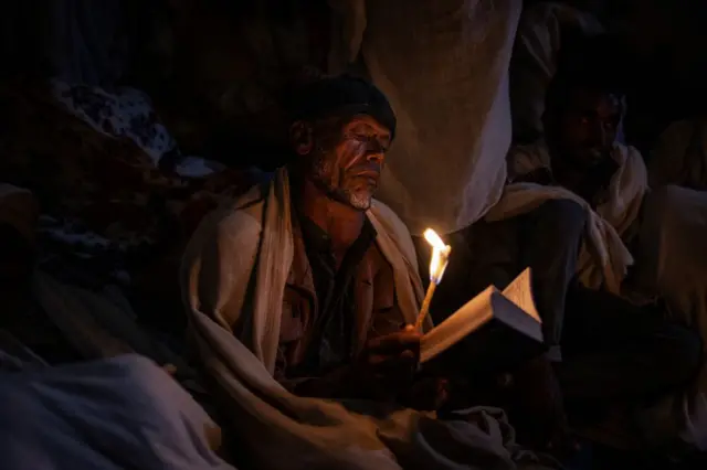 Pilgrims read prayers from bibles during the celebrations of Gena, the Ethiopian Orthodox Christmas, at Bete Mariam church in Lalibela on January 8, 2024.