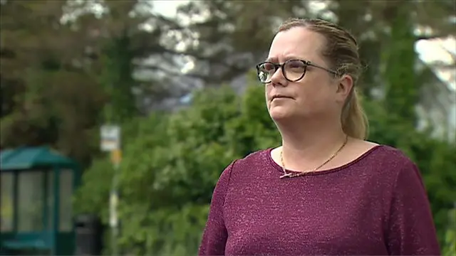 Lorraine Williams looks to the left, standing in a garden