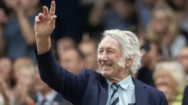 JPR Williams acknowledges the crowd as a celebrity guest at Wimbledon in July, 2023