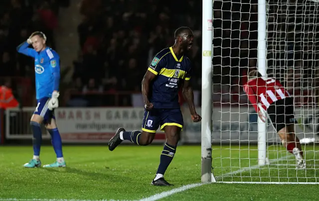 Viljami Sinisalo of Exeter City reacts after failing to save a penalty as Emmanuel Latte Lath