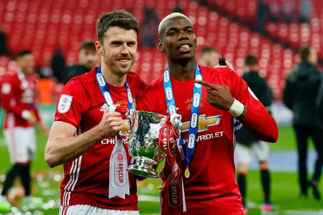 Paul Pogba and Michael Carrick celebrate with the League Cup trophy