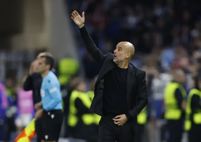 Guardiola gestures to his players from the touchline