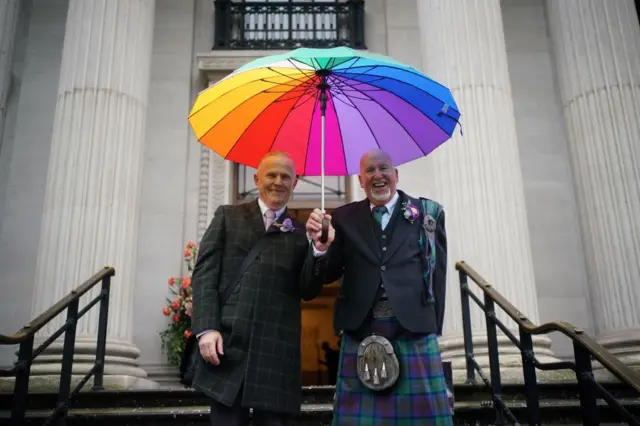 Andy Lambert, 68, and Mel Fawcus, 73, on the steps at Old Marylebone Town Hall in London