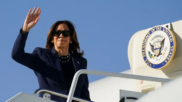 Kamala Harris waves to onlookers before boarding her official aircraft on Monday