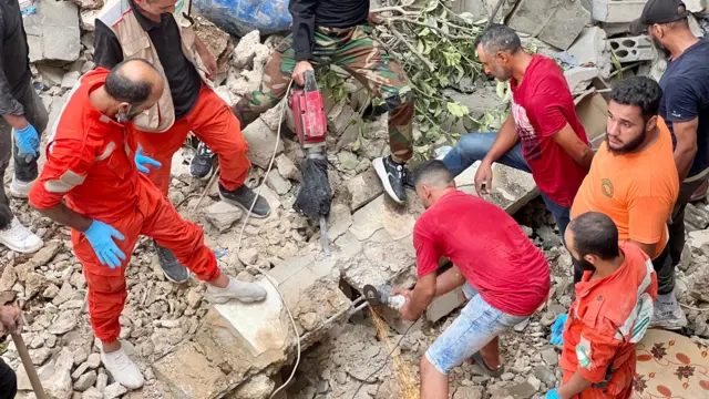 Search and rescue team members try to find victims following an overnight raid by the Israel army on the Palestinian refugee camp, Ain Al Hilweh, in Lebanon