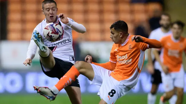 Blackpool and Lincoln players challenge for the ball