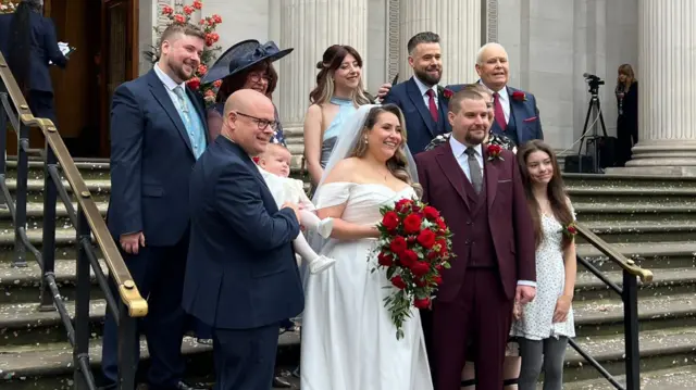 Georgia and Conor on the steps of the town hall with their guests either side