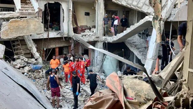 Search and rescue team members try to find victims following an overnight raid by the Israel army on the Palestinian camp of Ain Al Hilweh