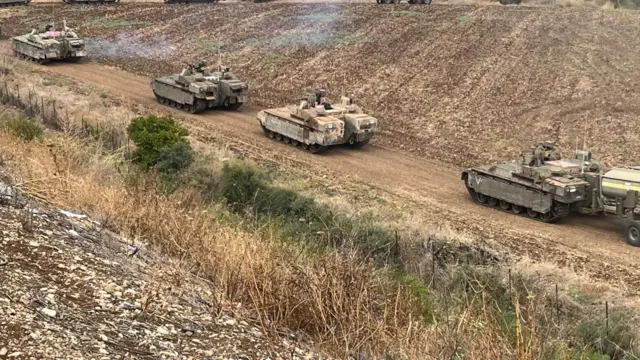 A view on tanks manoeuvring into a column on the eastern side of the Israel-Lebanon border