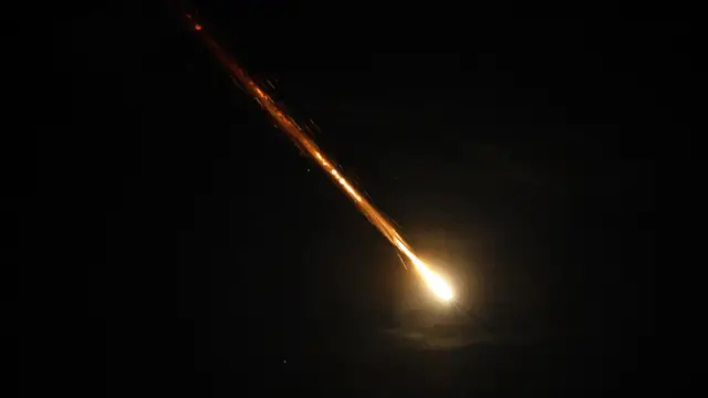 A rocket flies in the sky, as seen from Ashkelon, Israel