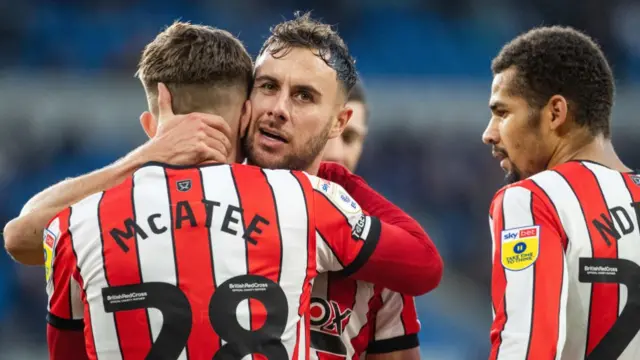 James McAtee being embraced by Sheffield United team-mate George Baldock