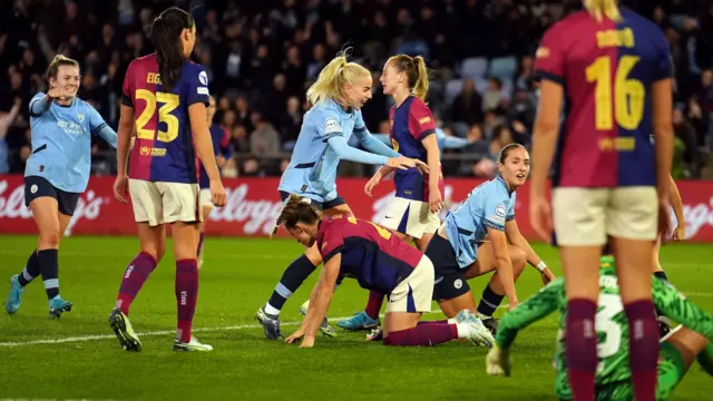 Naomi Layzell gets to her feet after scoring against Barcelona while her Manchester City team-mates celebrate