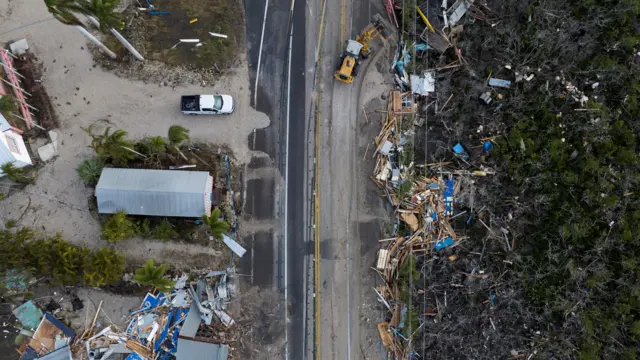 A bulldozer removes debris from a road after Hurricane Milton made landfall in Matlacha, Florida