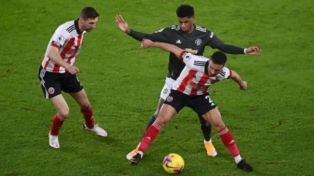 Chris Basham and George Baldock playing against Manchester United's Marcus Rashford