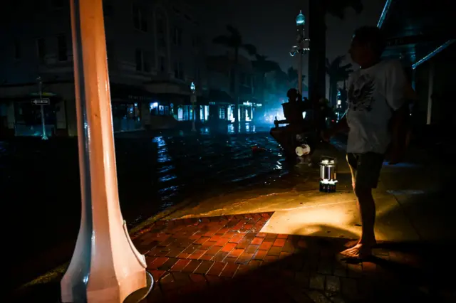 A man watches a flooded street in Florida
