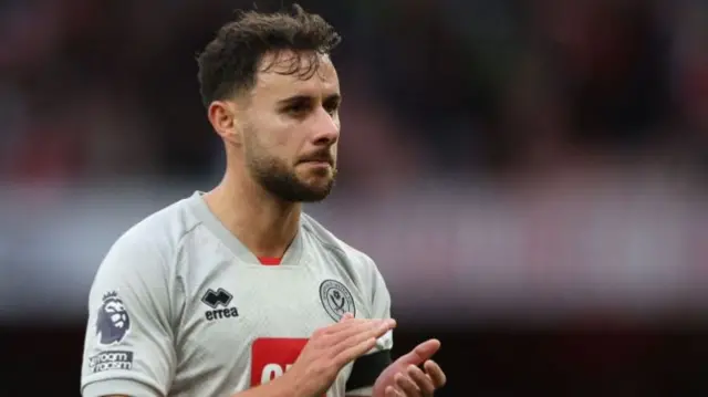 George Baldock applauds during a game for Sheffield United