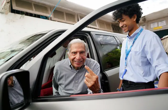 Ratan Tata shows his index finger with the indelible ink mark as he leaves a polling station after casting his ballot during the national elections in Mumbai, May 20, 2024