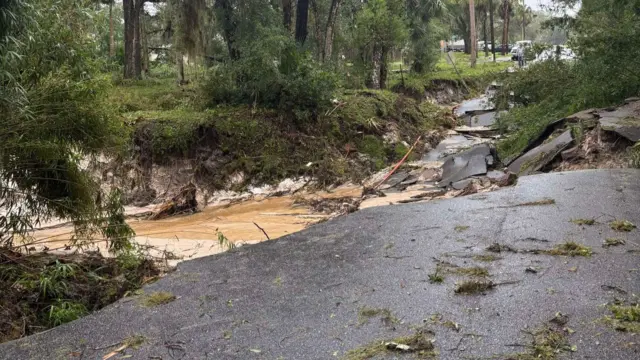 Muddy water flows in crevice filled with tarmac