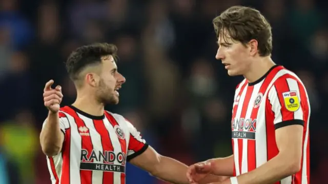 George Baldock speaks to Sheffield United team-mate Sander Berge during a game