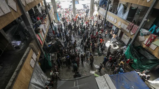 Displaced Palestinians inspect damage inside Rafida school, sheltering people, following attack