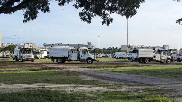 Several white disaster response trucks in a field