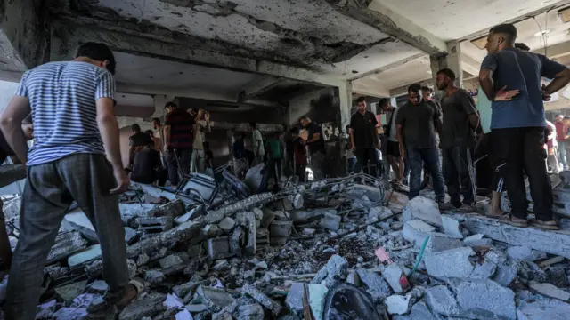 Displaced Palestinians search for missing people under the rubble at Rafida school