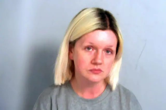 Police mugshot of Virginia McCullough. She has dyed shoulder-length blonde hair with dark roots showing