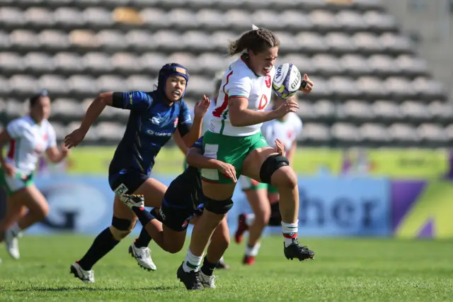 Natalia John of Wales attempts to break the tackle