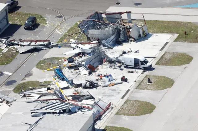 An aerial view shows the damaged Albert Whitted Airport as people try to clean it up