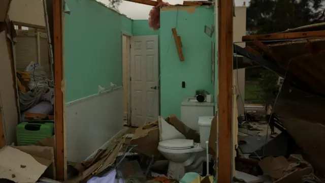 The remains of a house are seen in Florida. A toilet and what appears to be a bathroom are surrounded by debris