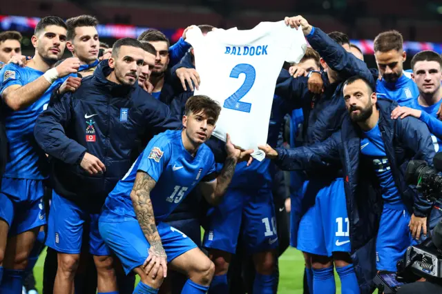 Greece pose with George Baldock's shirt