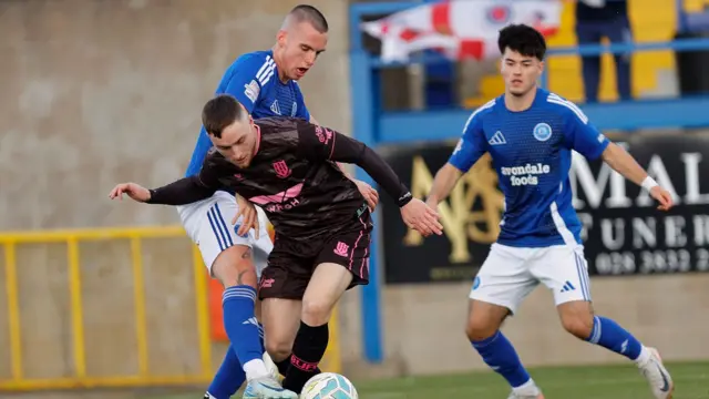 Glenavon's James Carroll challenges Ballymena's Calvin McCurry at Mourneview Park