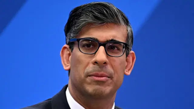 Rishi Sunak with black-rimmed glasses on