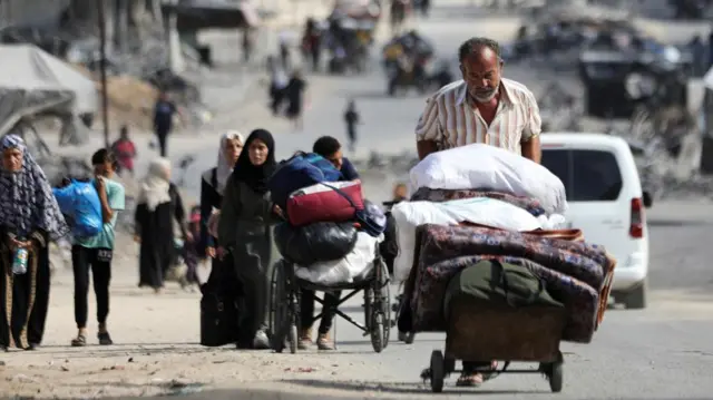 A man pushes a cart carrying his belongings.