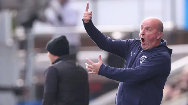 Chesterfield manager Paul Cook delivers instructions to his team