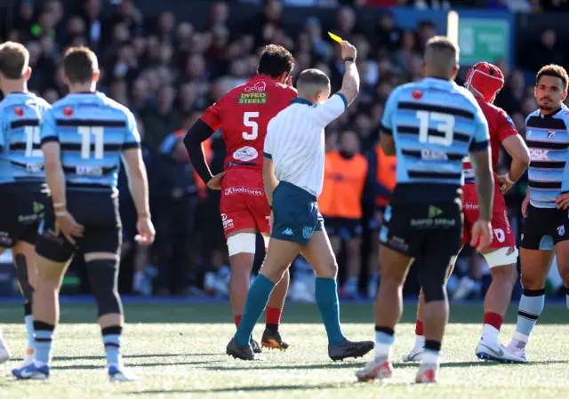 Sam Lousi is shown a yellow card