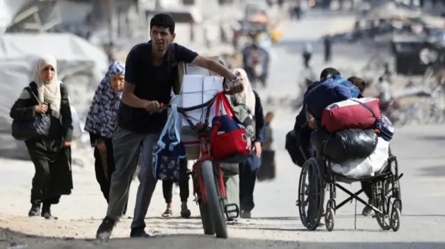 People pushing bikes and a wheelchair packed with their belongings as they flee northern Gaza, picture taken 12 October