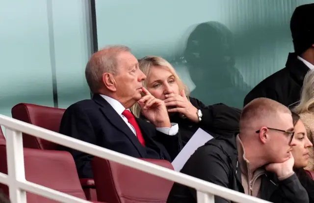 Akers and Hayes chat in the executive box