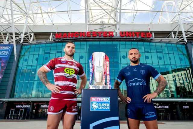 Kaide Ellis (Wigan) and Elliot Minchella (Hull KR) posing with Super League trophy outside Old Trafford