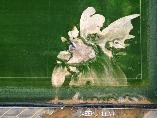 The damaged pitch at Plough Lane with sand exposed on the turf